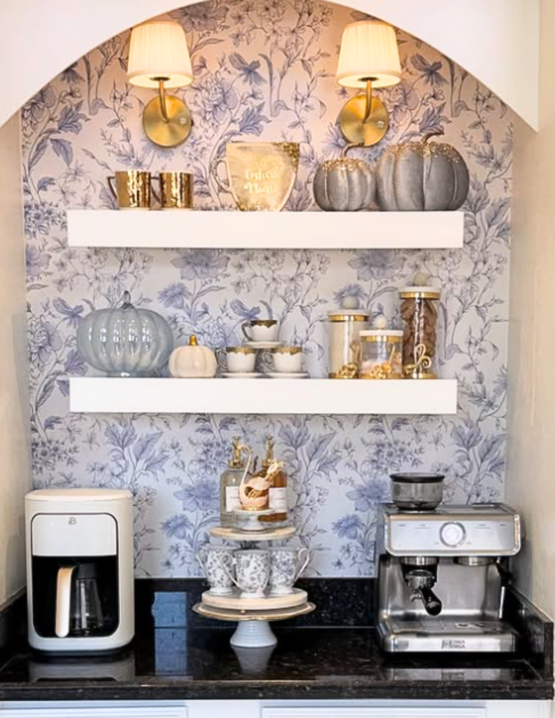 Arched coffee bar niche with blue and white chinoiserie wallpaper, brss sconces and tiered serving stand