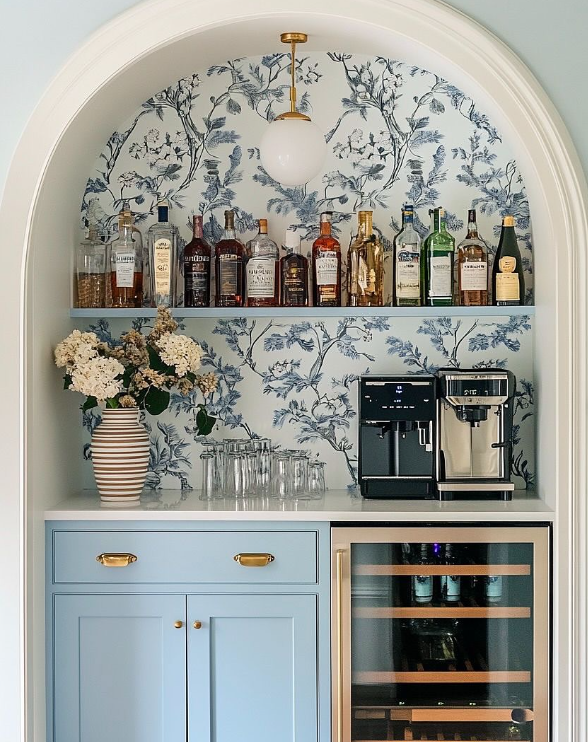 Arched niche coffee bar with chinoiserie wallpaper, light blue cabinetry, and dual beverage functionality