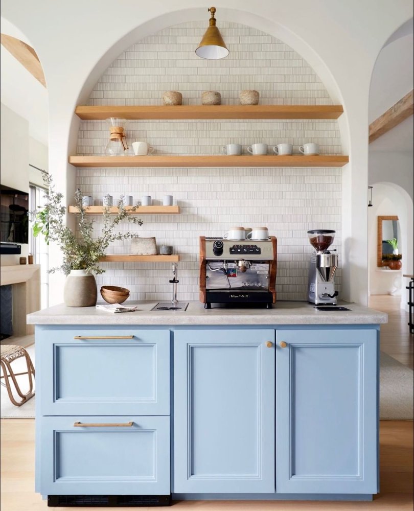  Light blue kitchen built in with arched coffee alcove, brass floating shelves, and white tile backsplash