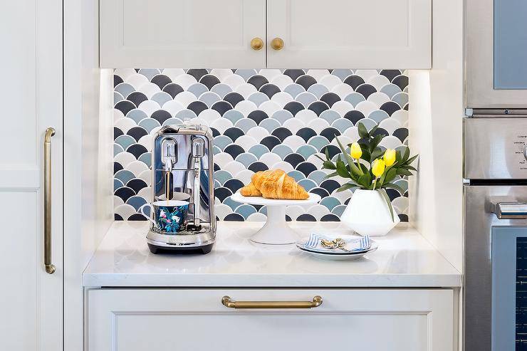 White kitchen with blue scallop tile backsplash and brass hardware coffee area