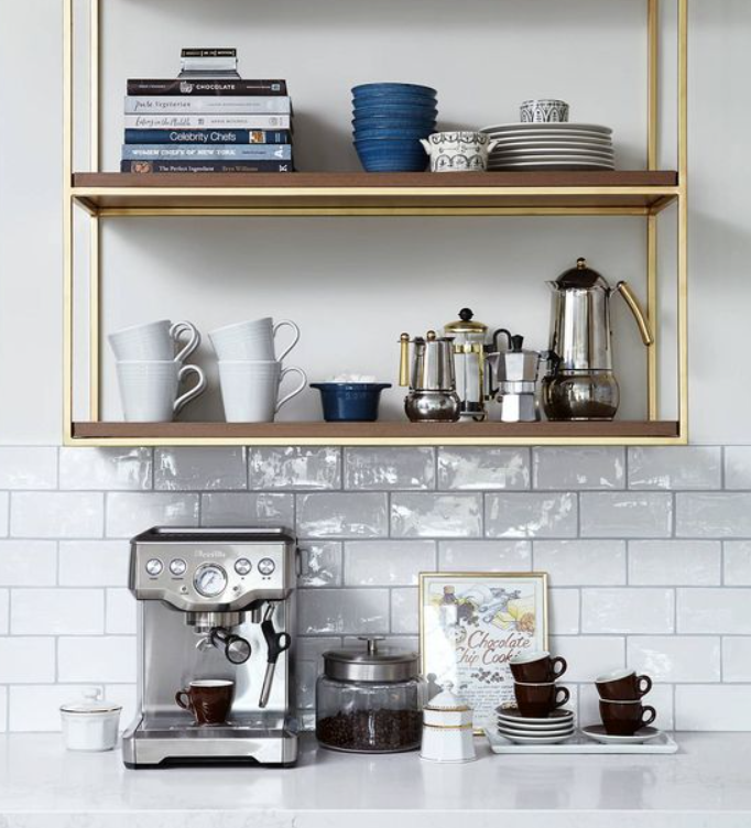  Brass frame open shelving with blue bowls, white mugs, and professional espresso machine