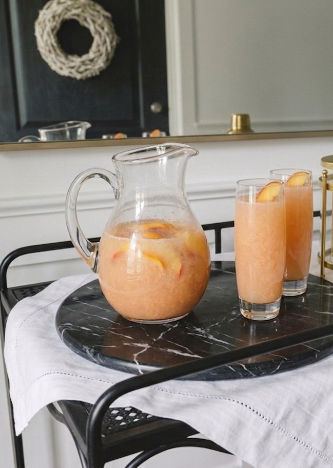 a pitcher with bellini cocktails and glasses